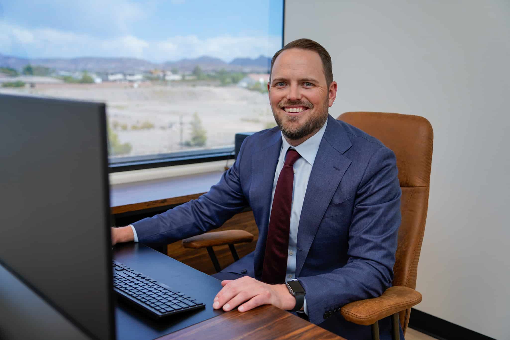 Lawyer at desk smiling in front of computer